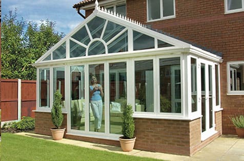 A house with a glass conservatory in front of it.