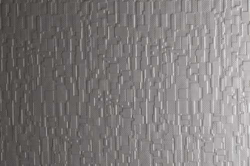 A close up of a grey wall with a pattern of squares.