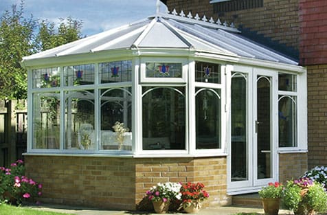 A white conservatory in front of a house.